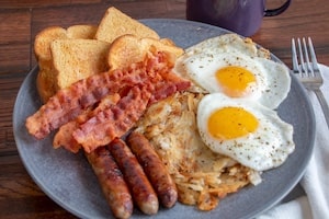 Sunday brunch plate with eggs, bacon, sausage and hash browns