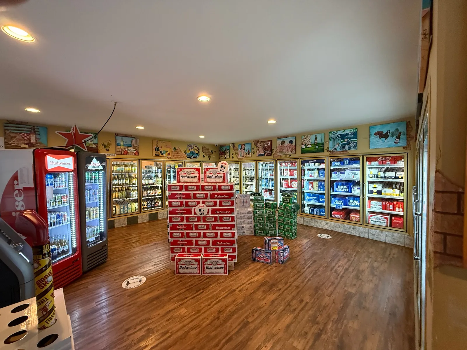 Cold beer coolers and hand painted wall panels inside the Black Swan Liquor Store in Shawnigan Lake