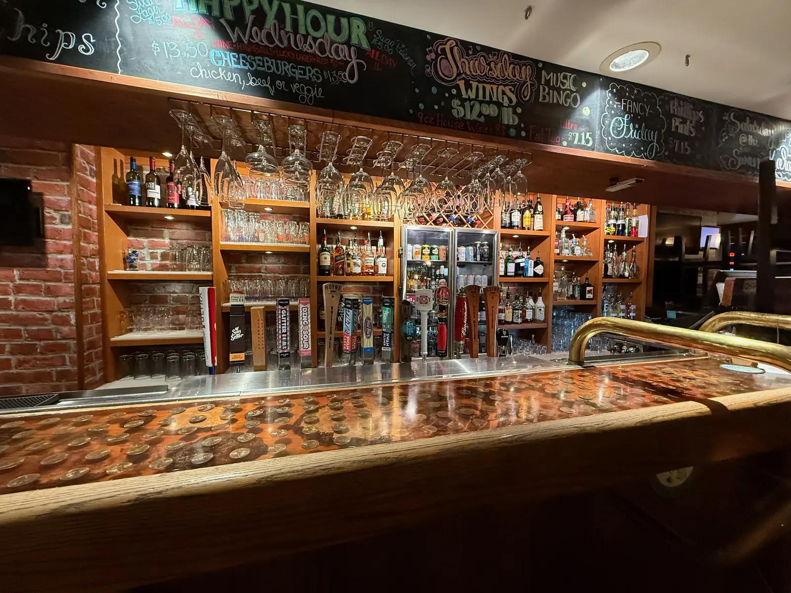 The bar at the Black Swan Pub, taps and glassware under the hand lettered specials board